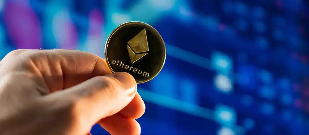 Ethereum érme kézben, kriptovaluta piaci háttérrel