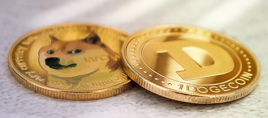 Arany színű Dogecoin kriptovaluta érme közelről.